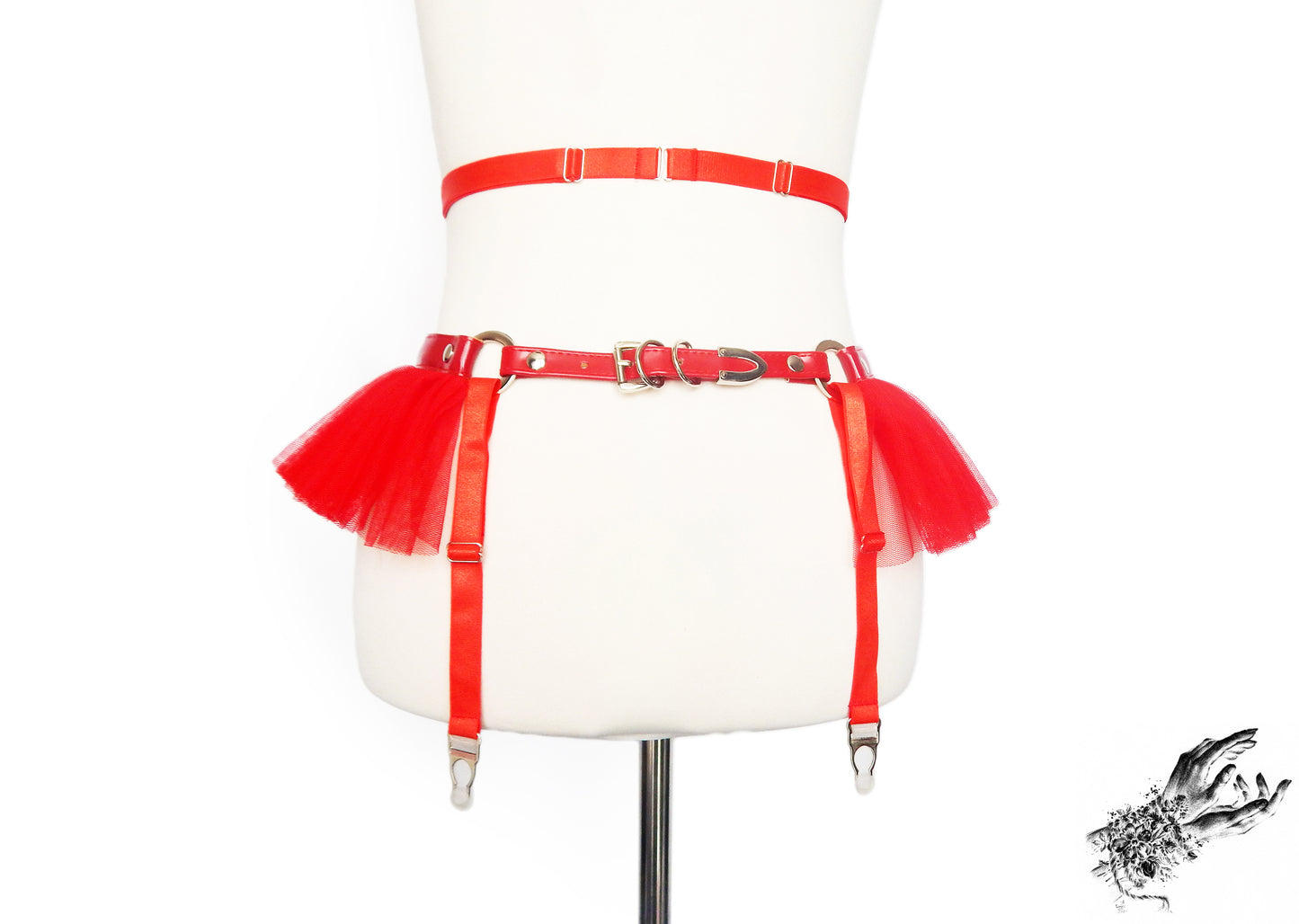 Rear view of a red faux leather garter belt showing the adjustable elastic waist and suspender straps with buckled vegan leather hip strap, displayed on a mannequin against a white background.