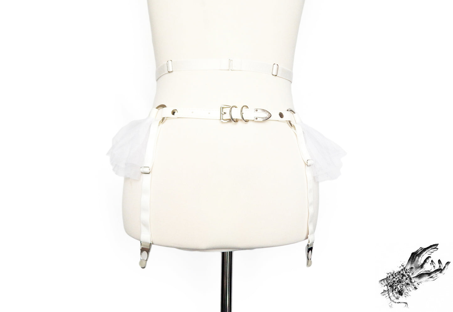 Rear view of a white faux leather garter belt featuring adjustable elastic waist and suspender straps and buckled faux leather hip strap, displayed on a mannequin against a white background.
