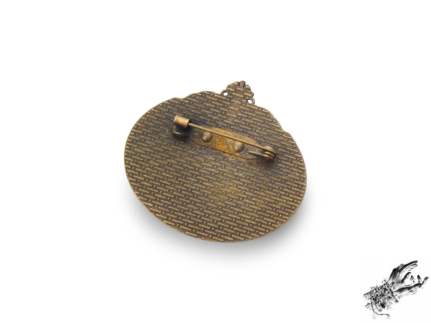 Rear view photo of the antique bronze and ivory bat cameo brooch, showing the bronze brooch pin securely fastened at the top of the ornate frame, inspired by Victorian gothic fashion