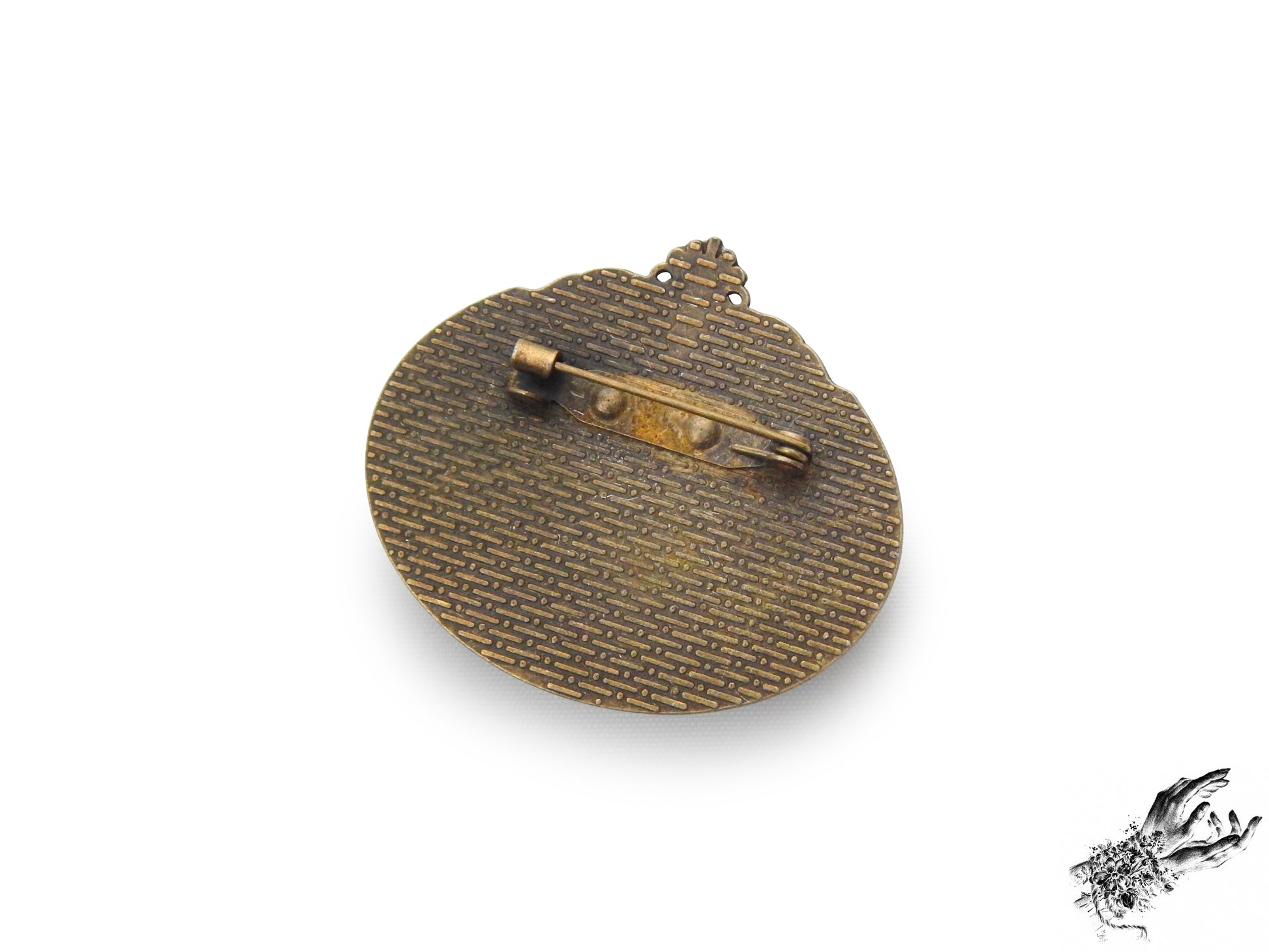 Rear view photo of the antique bronze and ivory bat cameo brooch, showing the bronze brooch pin securely fastened at the top of the ornate frame, inspired by Victorian gothic fashion