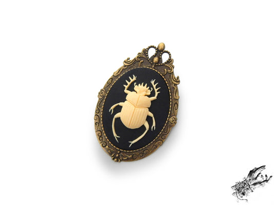 Antique bronze brooch featuring a black and ivory resin beetle cameo in an ornate bronze frame, inspired by Victorian gothic fashion and mourning jewellery in the UK