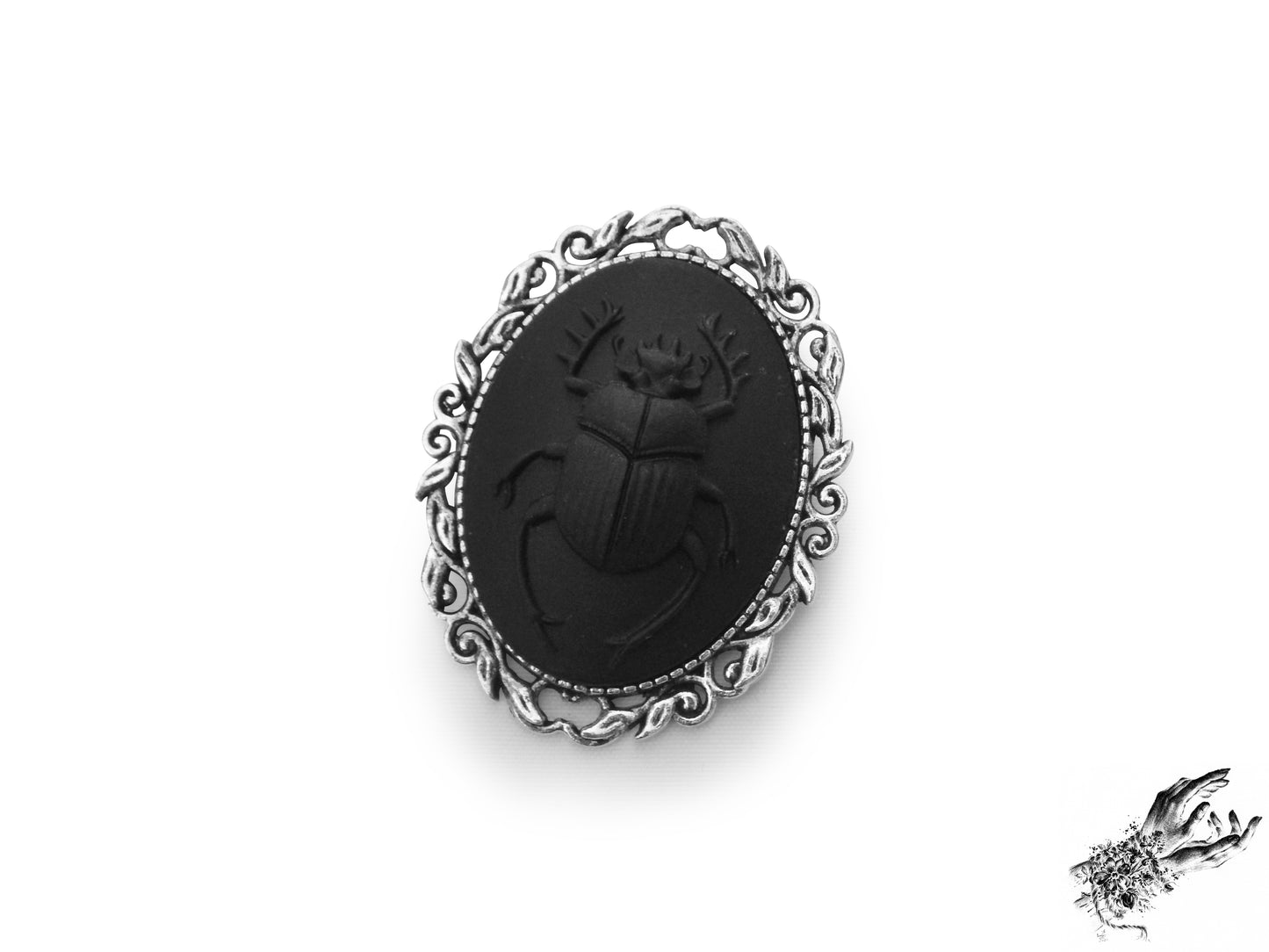 Antique silver brooch featuring a black resin beetle cameo in an ornate silver plated frame, inspired by Victorian gothic fashion and mourning jewellery in the UK