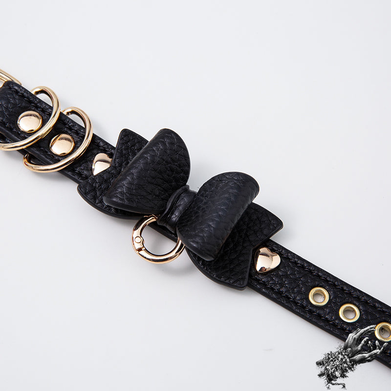 Black leather wristband with kawaii bow design and gold hardware, designed in the UK for kawaii and pastel goth fashion