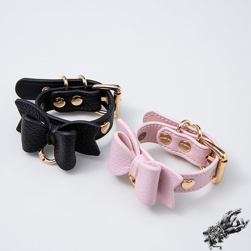 Black and Pink leather wristbands with kawaii bow design and gold hardware, designed in the UK for kawaii and pastel goth fashion