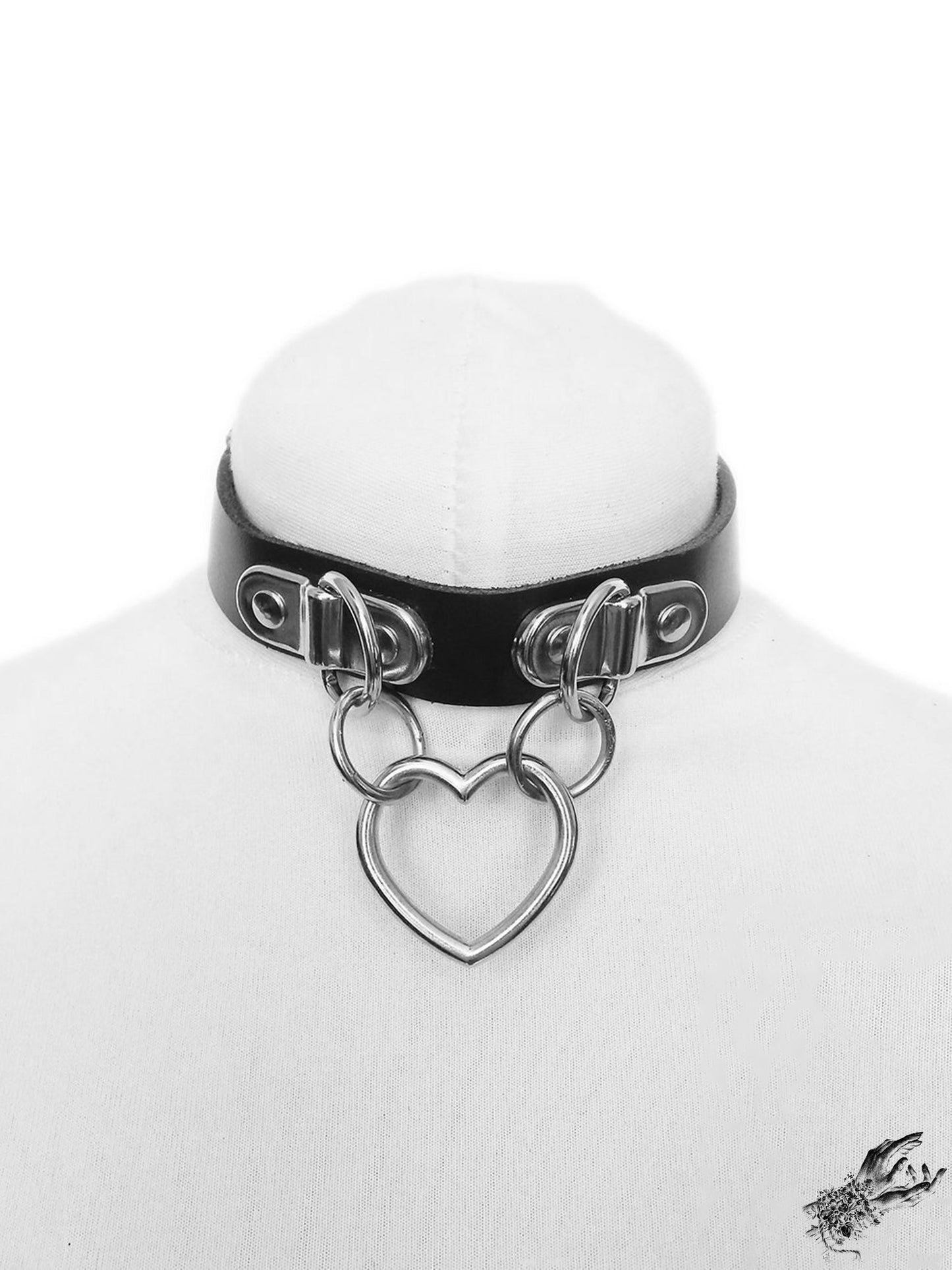 Black leather choker with a silver heart-shaped pendant on a white mannequin bust