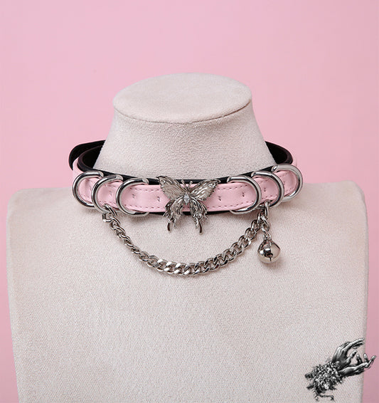 Black and pink leather choker featuring a ornate silver butterfly pendant, chunky chain and a dainty silver bell, worn on a mannequin bust