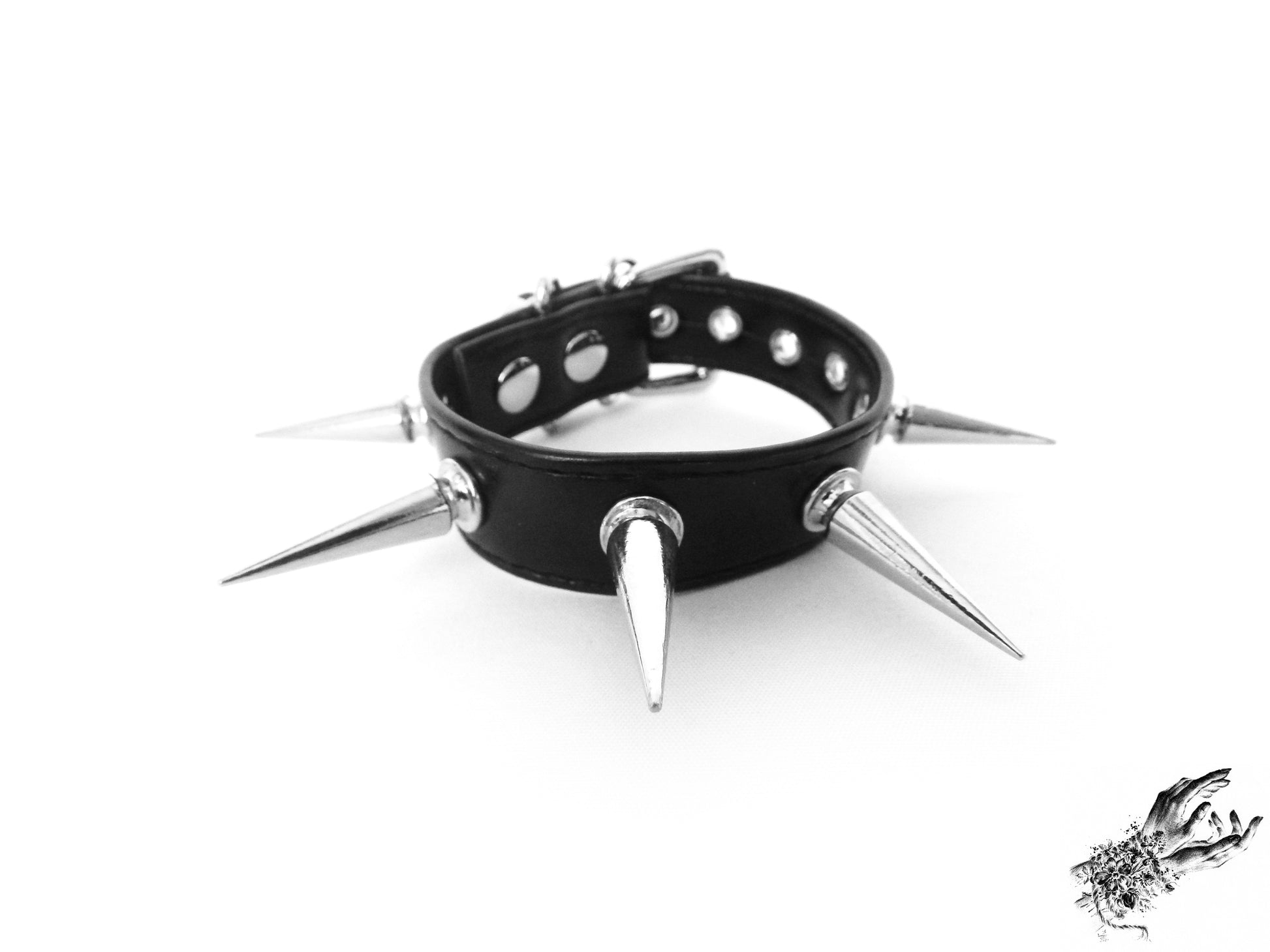 Close-up of the black faux leather wristband with 25mm spike studs and ajdustable buckle