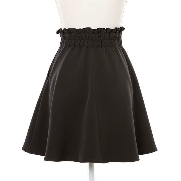 Back view of a black high waisted skirt featuring a partially elasticated waist with side zip fastening and pleated a-line design, displayed on a mannequin against a white background.