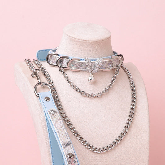 Blue leather choker and leash set featuring a silver diamante butterfly charm, chains, D rings and bell, with detachable chain leash and leather hand strap. Displayed on a white mannequin bust against a pink background for a Harajuku fashion aesthetic.