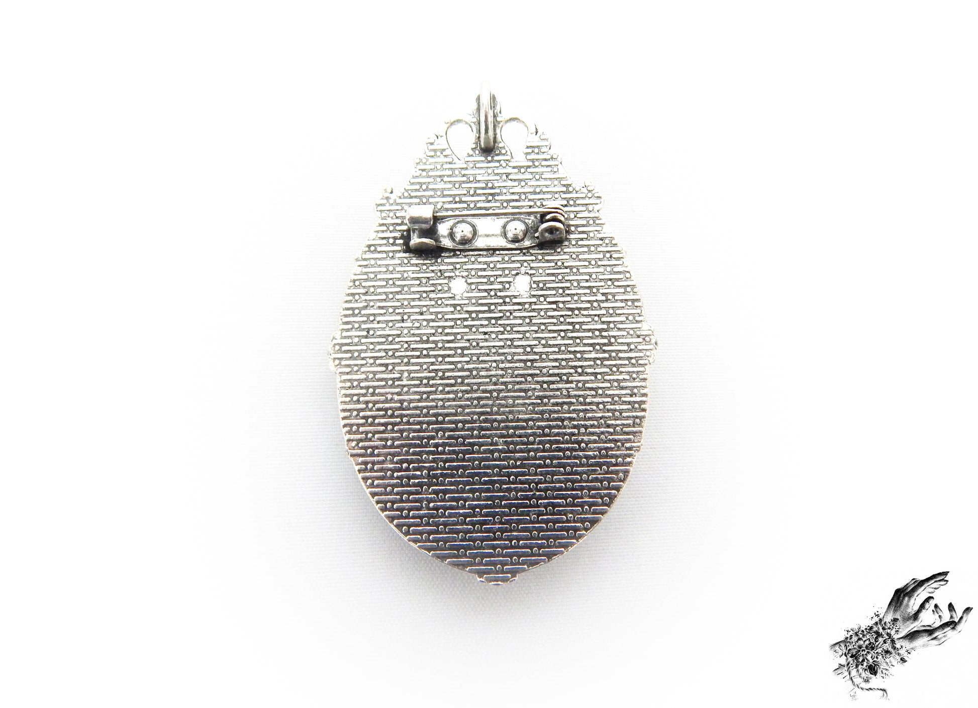 Rear view photo of the gunmetal black and ivory beetle cameo brooch, showing the black brooch pin securely fastened at the top of the ornate frame, inspired by Victorian gothic fashion