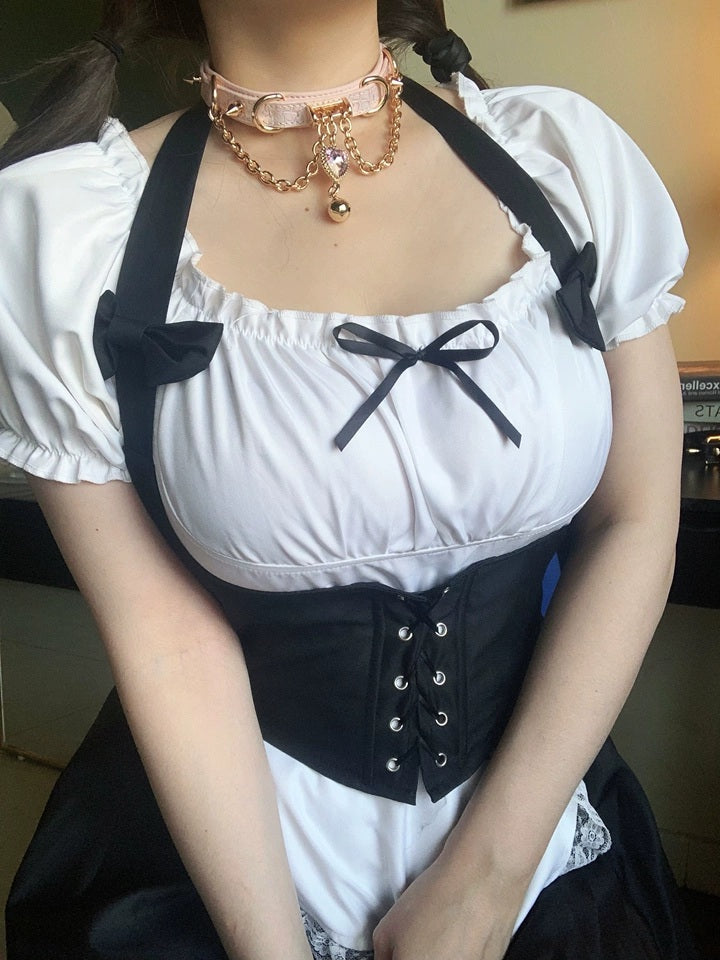 Worn photo of a pink leather choker featuring gold tone chains, D rings, spike studs, bell and pink and gold crystal heart charm. Styled with a black and white maid costume for a kawaii idol aesthetic.