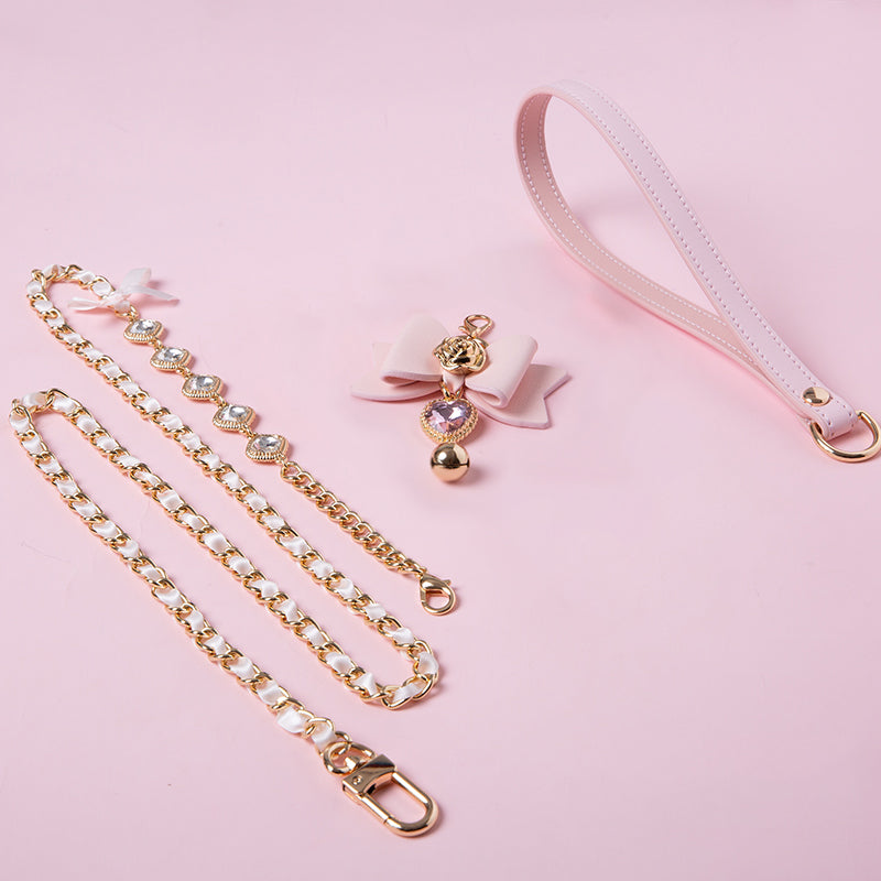 Pink and gold leash set featuring a leather hand strap, gold tone and glass diamante chain leash and cute detachable bow charm