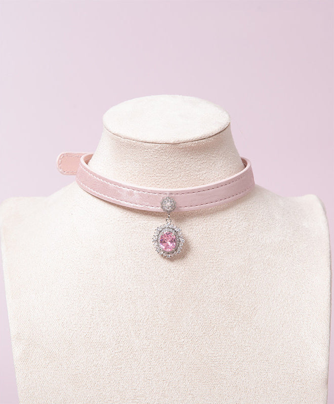 Pink leather choker featuring clear and pink crystal cameo and hardware. Displayed on a white mannequin bust against a pink background for a pastel goth aesthetic.