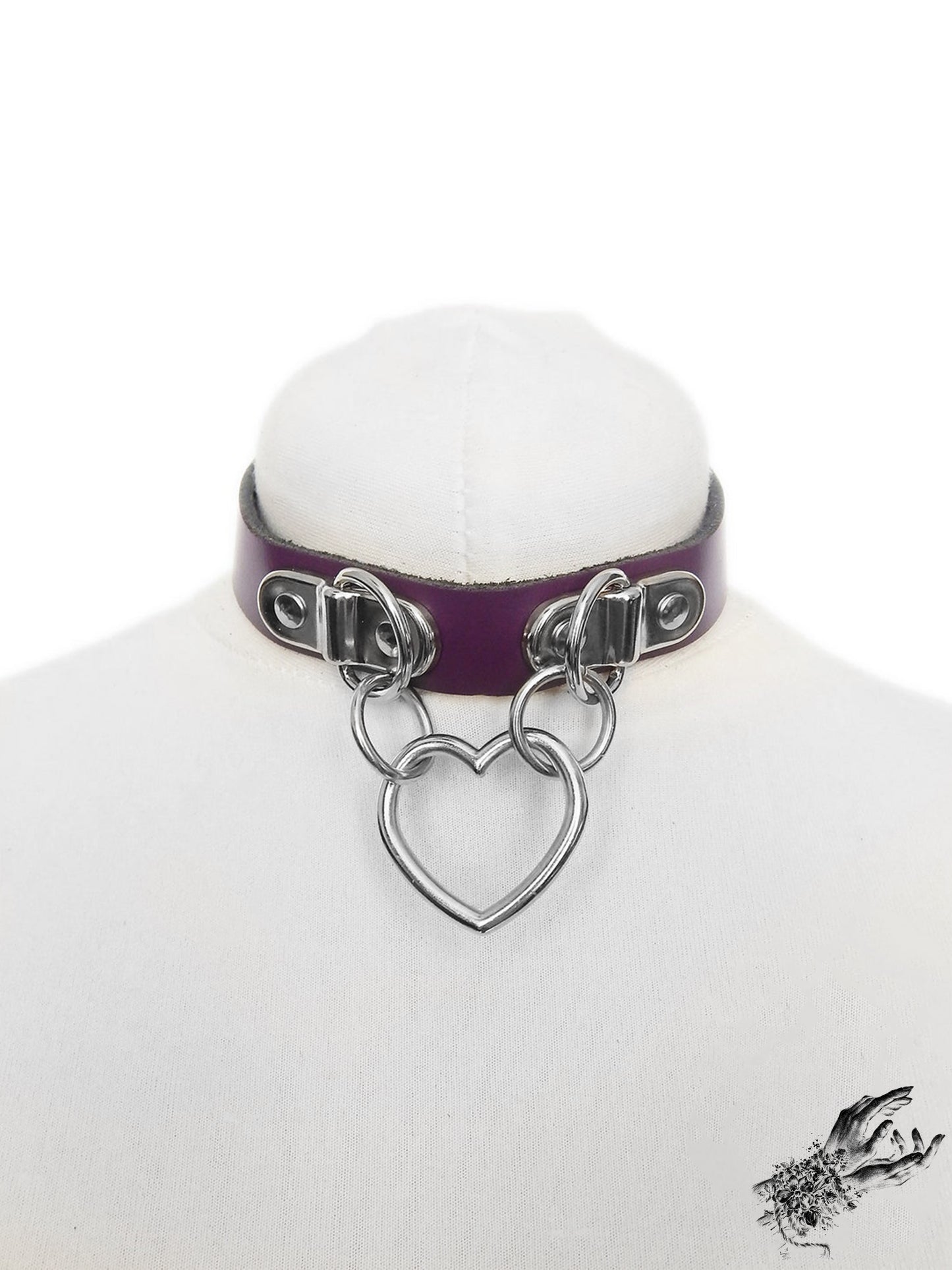 Purple leather collar with a silver heart-shaped pendant on a white mannequin bust