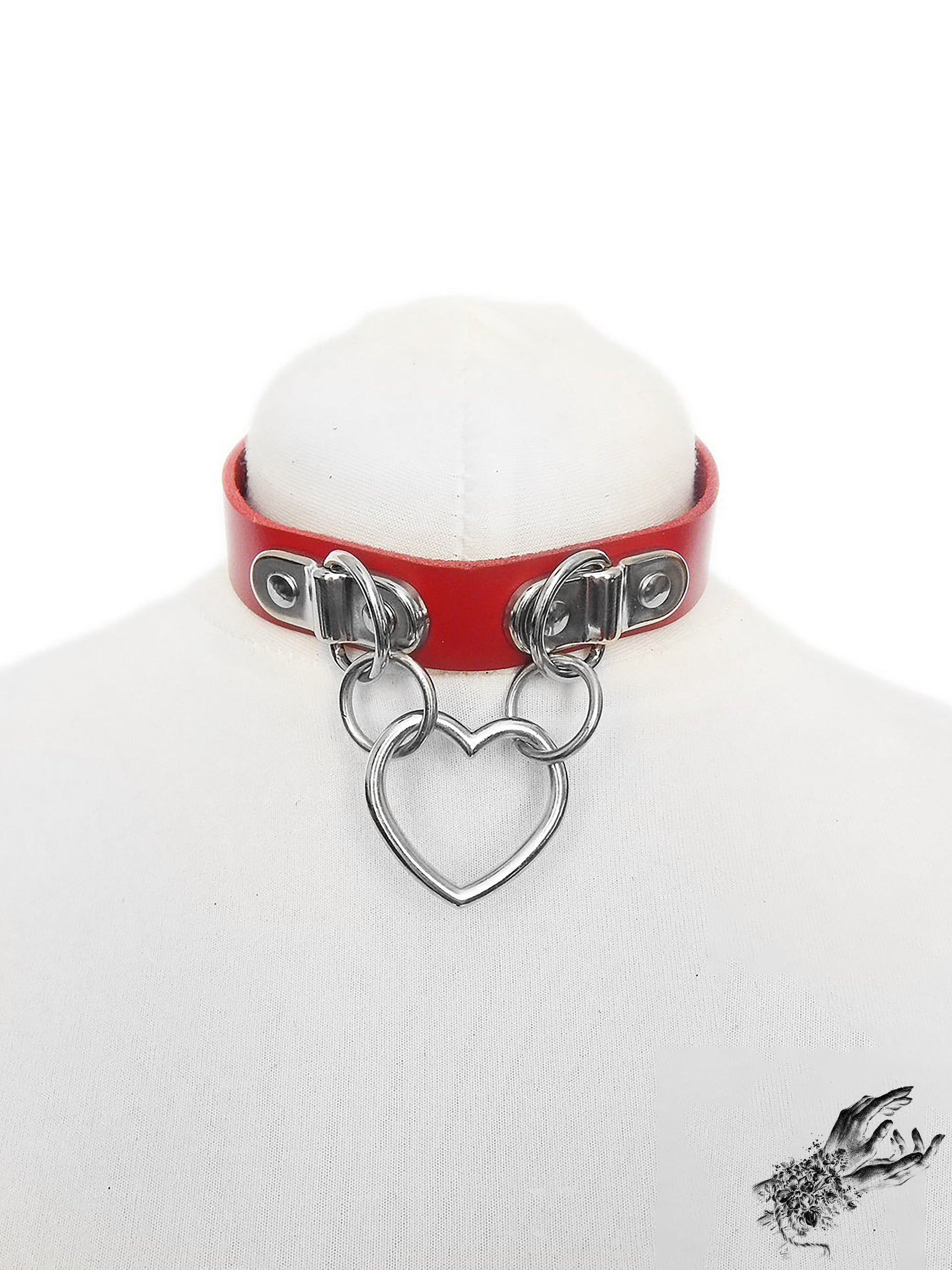 Red leather choker with a silver heart-shaped pendant on a white mannequin bust
