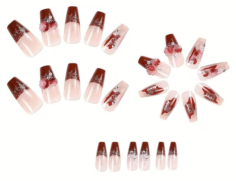 A set of 24 ballerina-shaped false nails arranged in four lines. The nails feature a glossy dark red ombre design starting from a sheer nude-pink base, decorated with silver glitter, white rhinestones, and red rose motifs.