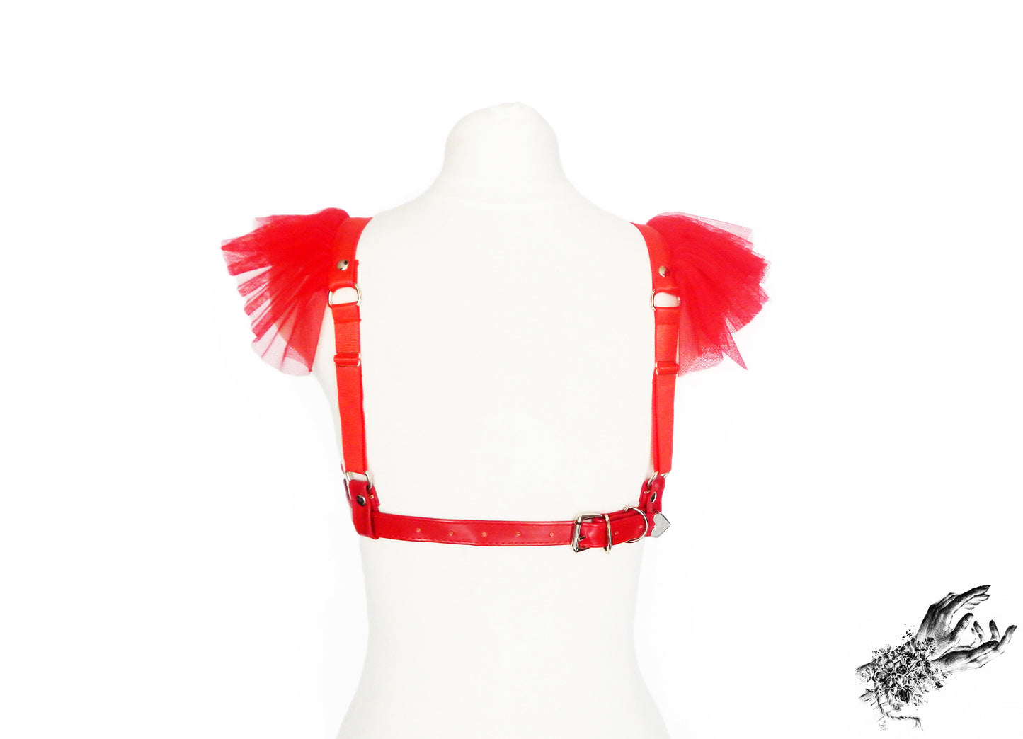 Rear view of a red vegan leather harness bra showing the adjustable elastic shoulder straps and buckled faux leather back strap, displayed on a mannequin against a white background.
