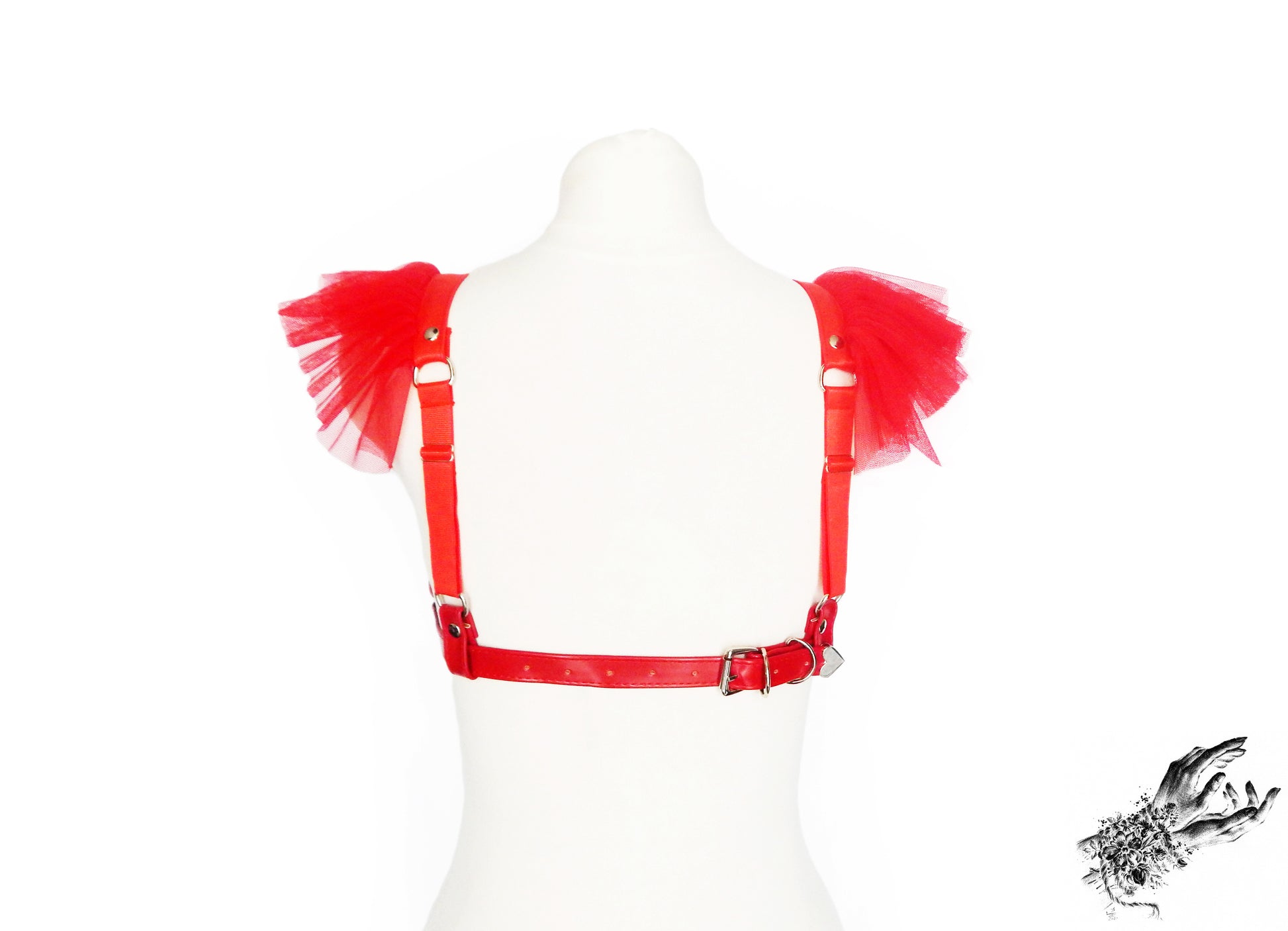 Rear view of a red vegan leather harness bra showing the adjustable elastic shoulder straps and buckled faux leather back strap, displayed on a mannequin against a white background.