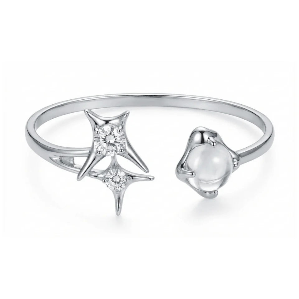 A silver plated costume jewellery bangle featuring a silver starburst design, wrap-around cuff and clear round glass crystal gemstones, displayed on a white background.