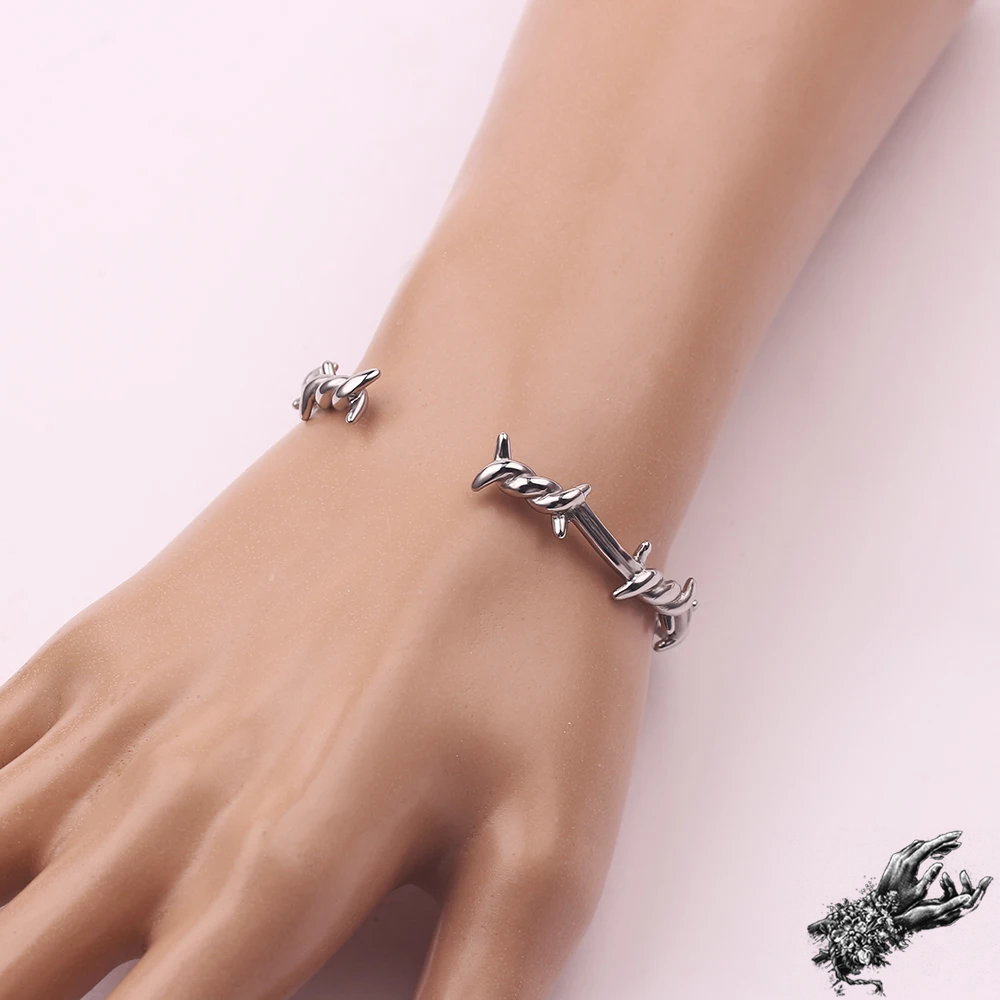 Mannequin photo of the stainless steel barbed wire bangle showing the adjustable open back for versatile sizing