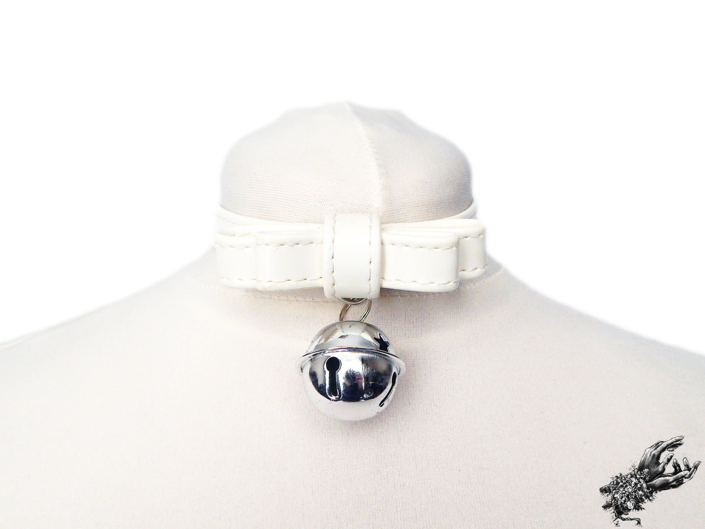 White faux leather bow choker featuring a silver bell design, displayed on a white mannequin bust