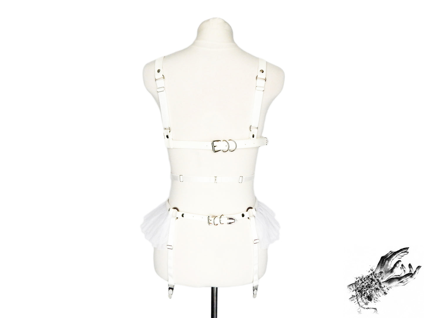 Rear view of a white vegan leather harness set showing the adjustable elastic and faux leather straps as well as adjustable suspender straps, displayed on a mannequin against a white background.