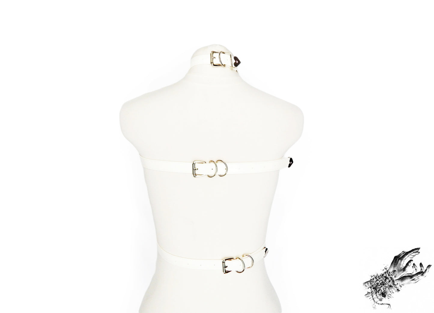 Rear view of a white vegan leather chest harness showing the adjustable buckled neck, chest and waist straps with silver hardware, displayed on a mannequin against a white background.