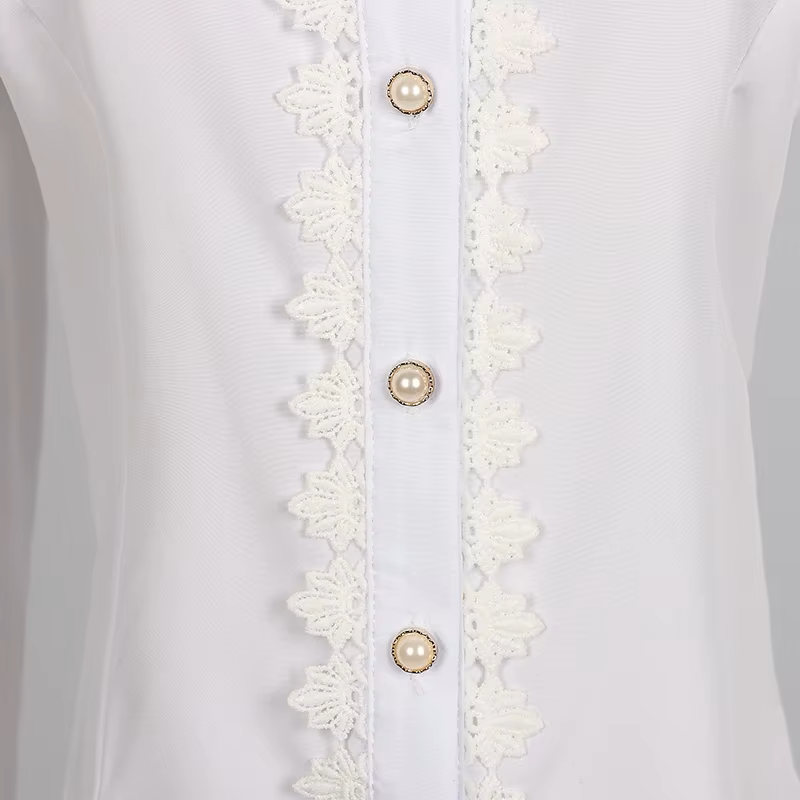 Close up photo of a white polyester blouse showing the gold and white pearlescent buttons and lace trimmed button placket.