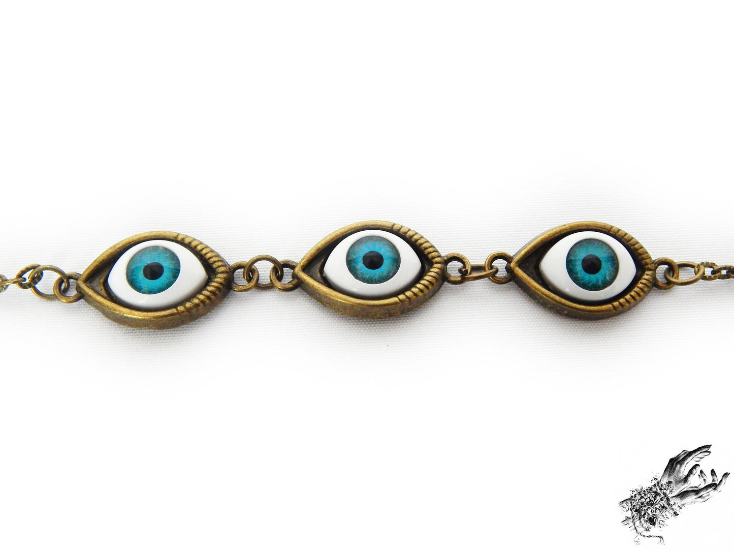 Close-up of the antique bronze and bright blue evil eye bracelet, showing the striking bright blue cameos in bronze frames