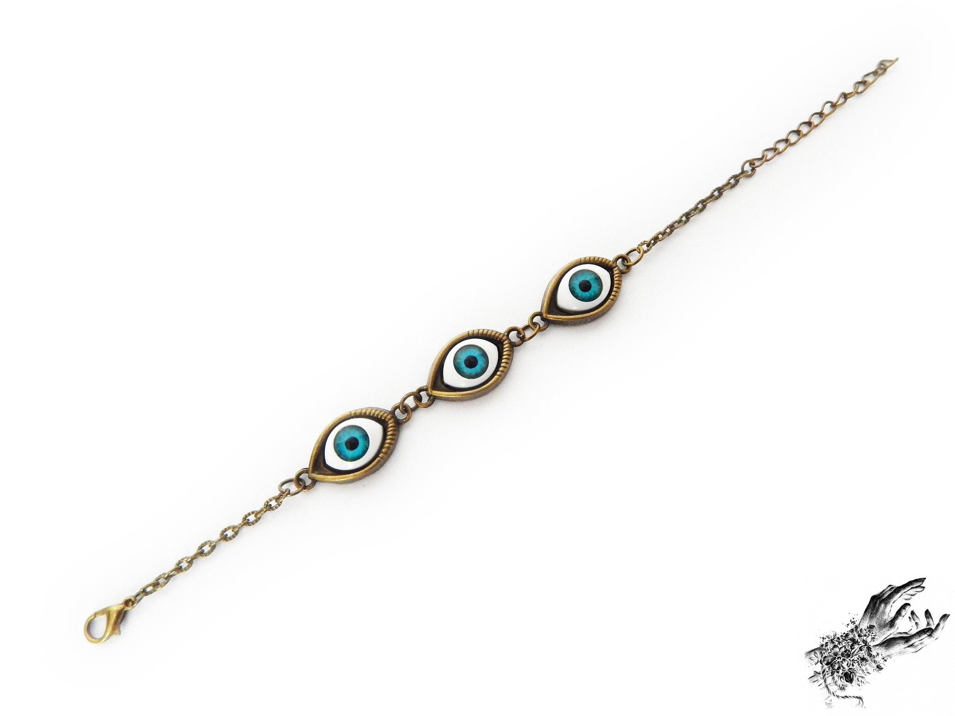 Vintage style antique bronze evil eye bracelet with bright blue irises displayed on a white background