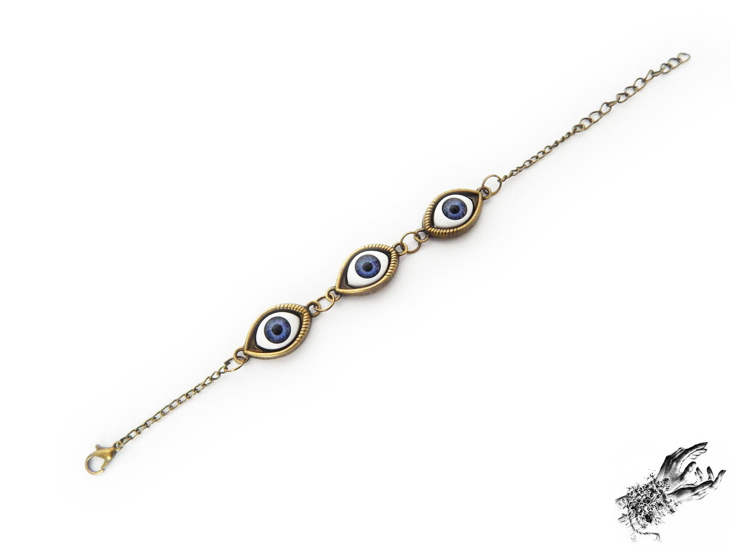 Antique bronze evil eye bracelet with navy blue irises in bronze cameo frames displayed on a white background and inspired by vintage fashion
