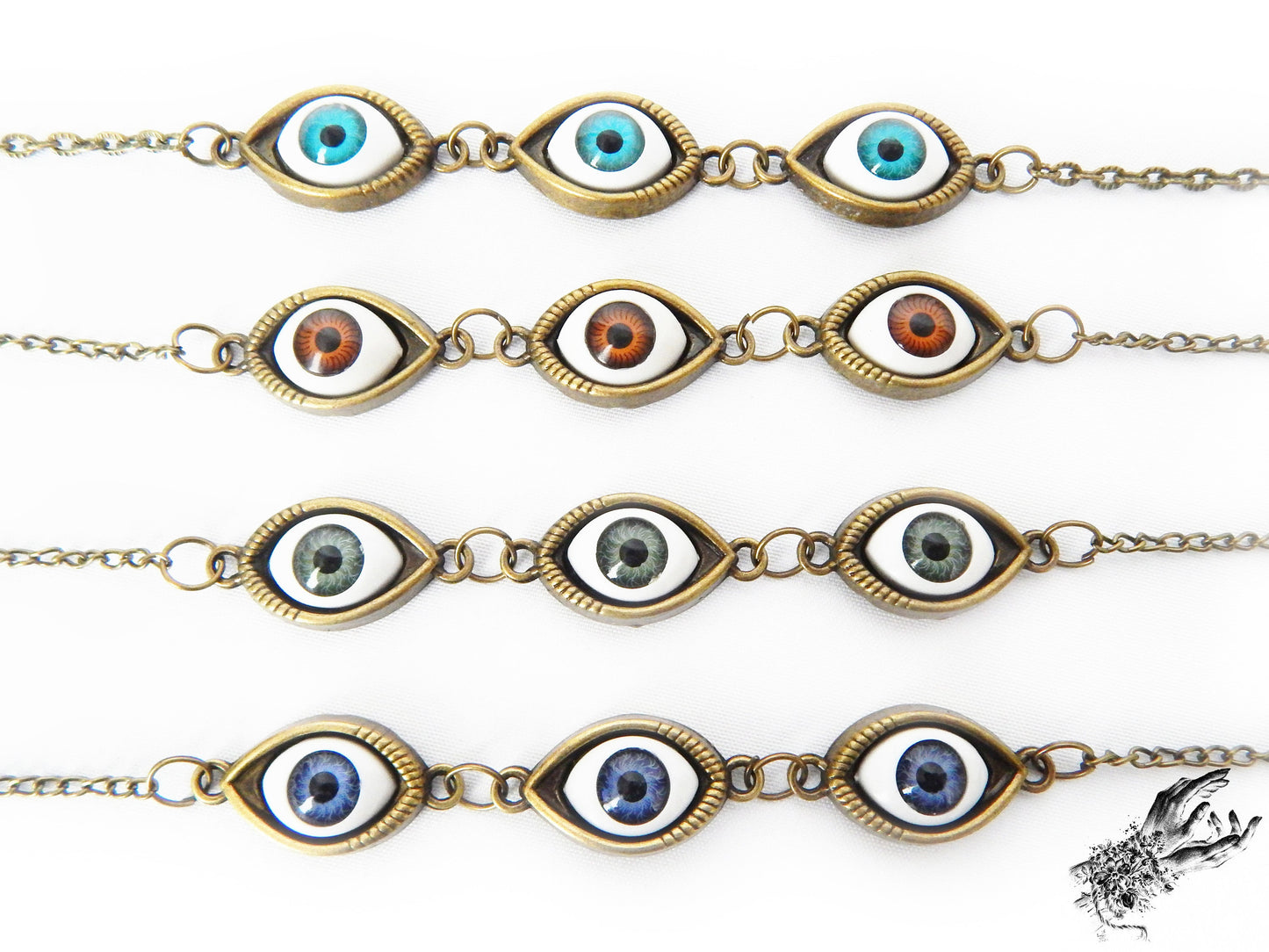 Close-up of the antique bronze evil eye cameo bracelets, showing the variety of iris colours in blue, green and brown displayed on a white background