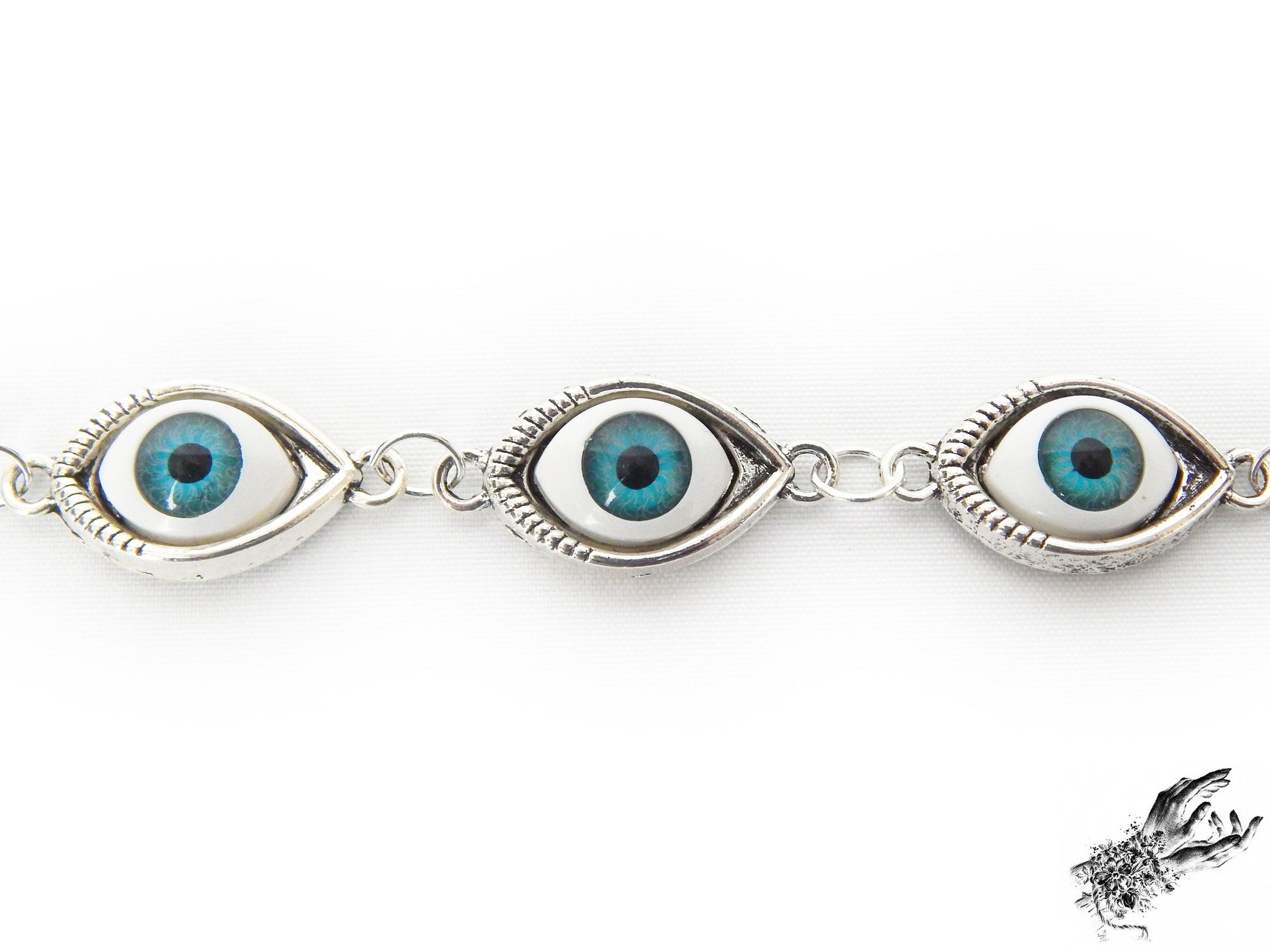 Close-up of the antique silver and blue evil eye bracelet, showing the striking bright blue cameos in silver frames