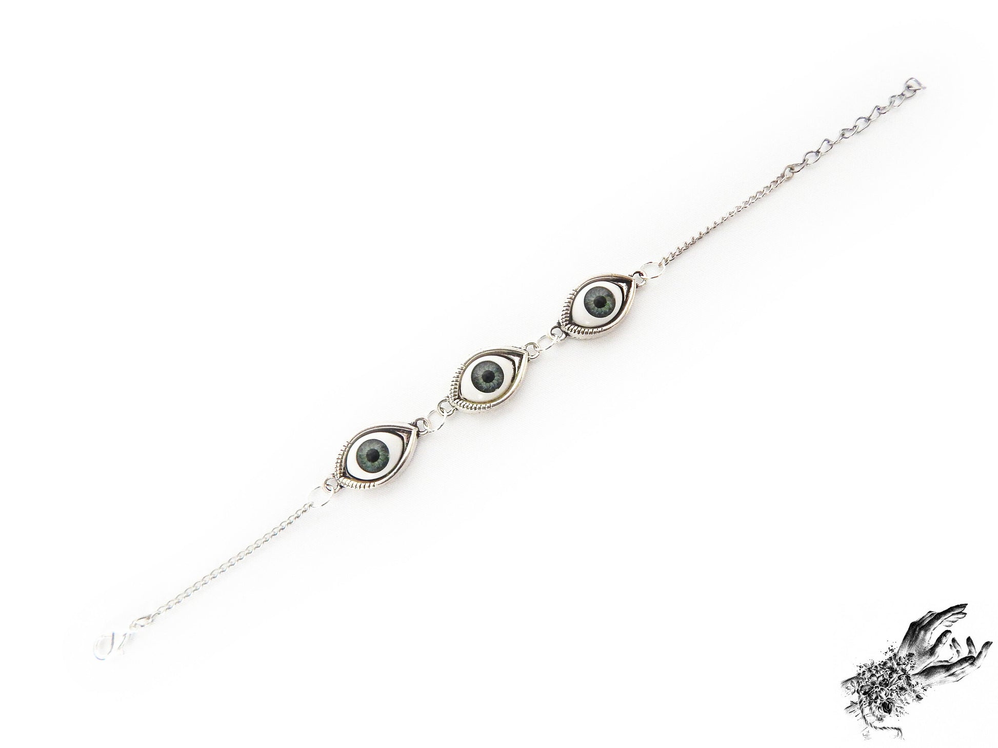 Antique silver evil eye bracelet featuring striking green irises in silver cameo frames for a vintage fashion aesthetic