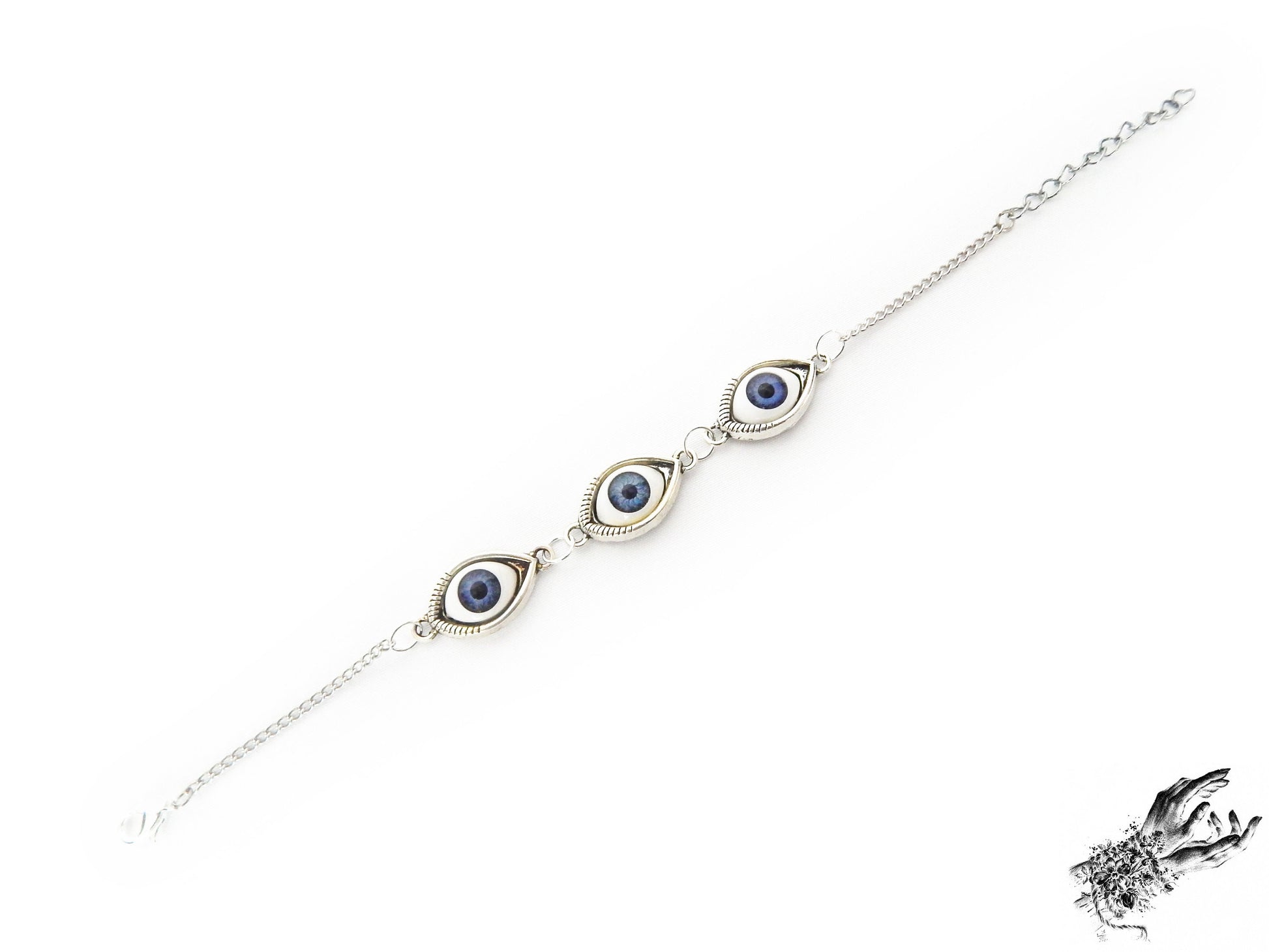 Antique silver evil eye bracelet with navy blue irises in silver cameo frames displayed on a white background and inspired by vintage fashion