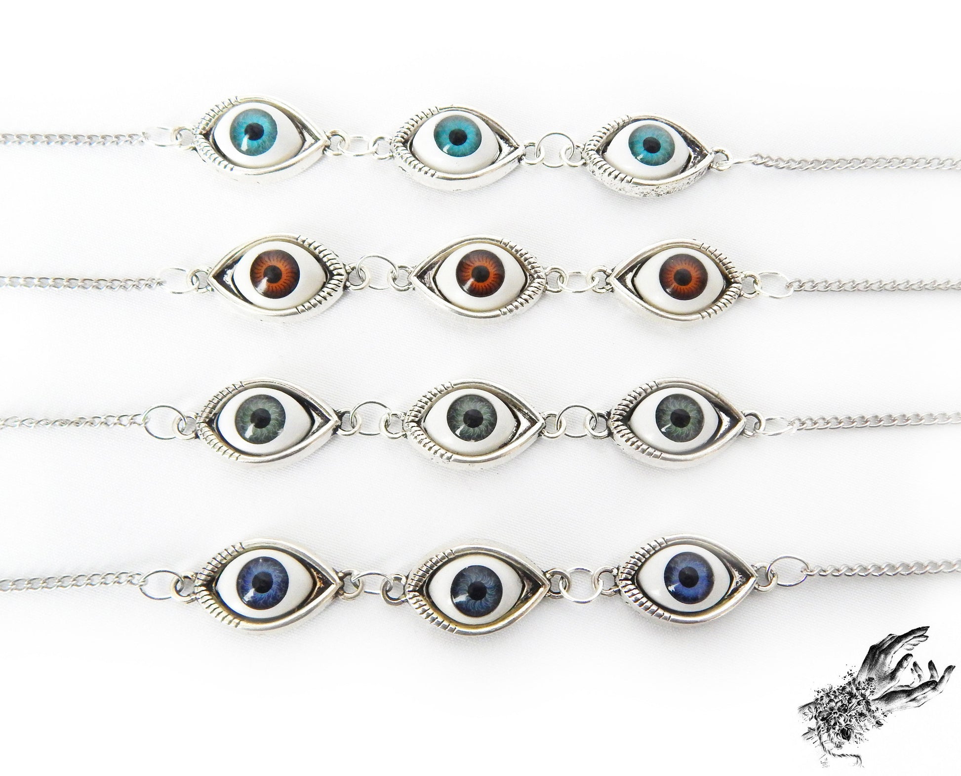 Close-up of the antique bronze evil eye cameo bracelets, showing the variety of iris colours in blue, green and brown displayed on a white background