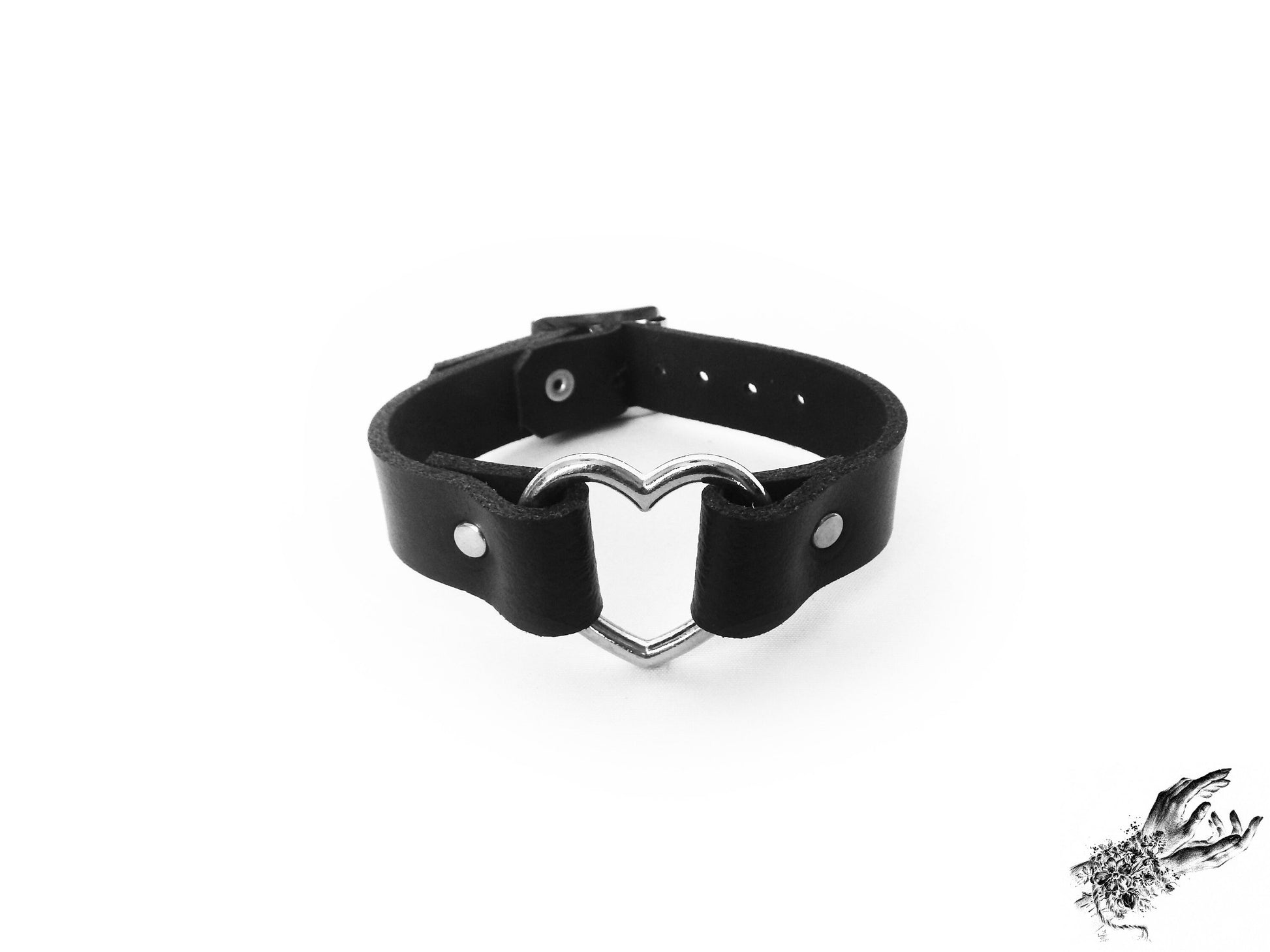 Black leather wristband featuring a central silver heart ring and adjustable buckle at the back, designed for gothic and alt fashion in the UK