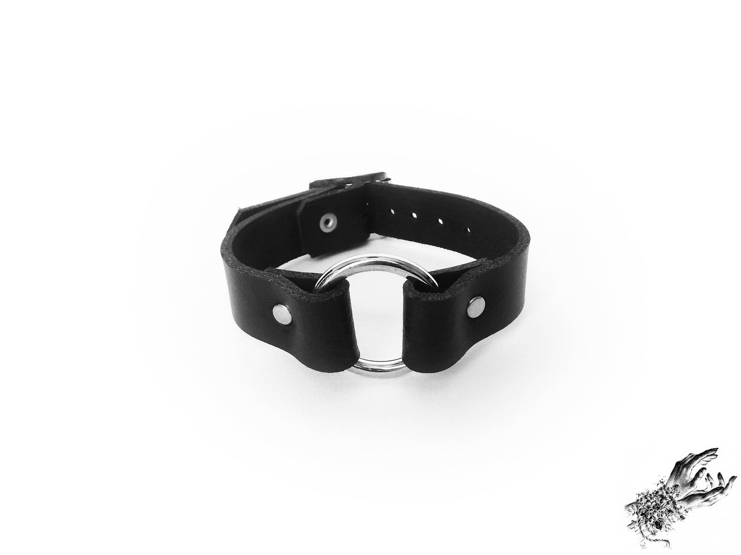 Black leather wristband featuring a central silver O ring and adjustable buckle on a white background