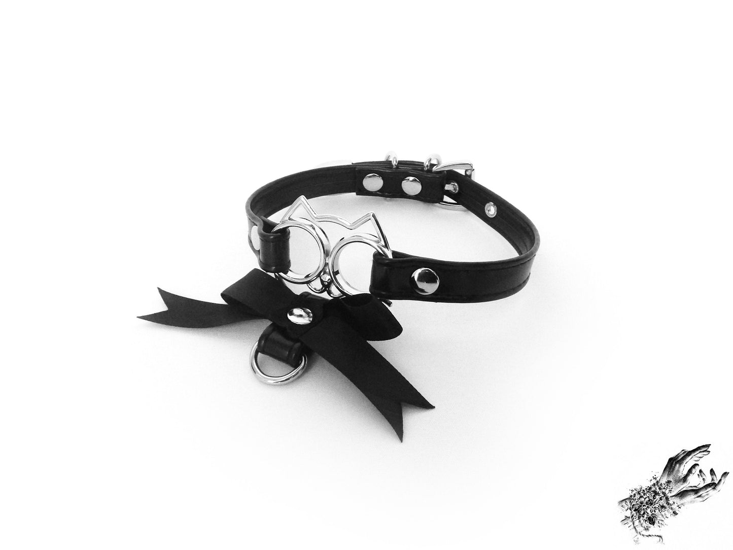 Black faux leather choker featuring a central silver cat shaped pendant and black satin ribbon charm, for a kawaii gothic aesthetic