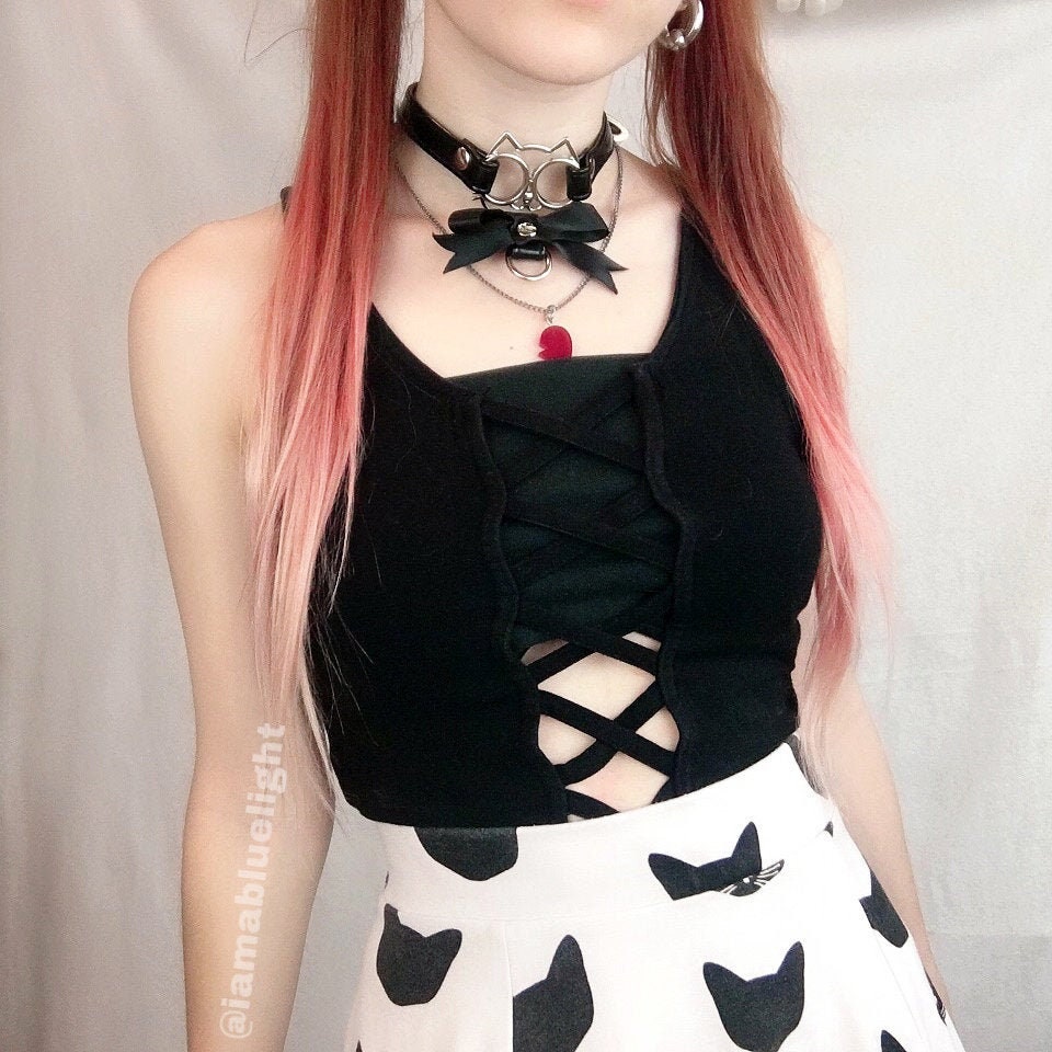Modelled photo of the black ribbon cat choker, styled with a black velvet top and pink hair for a pastel goth fashion aesthetic