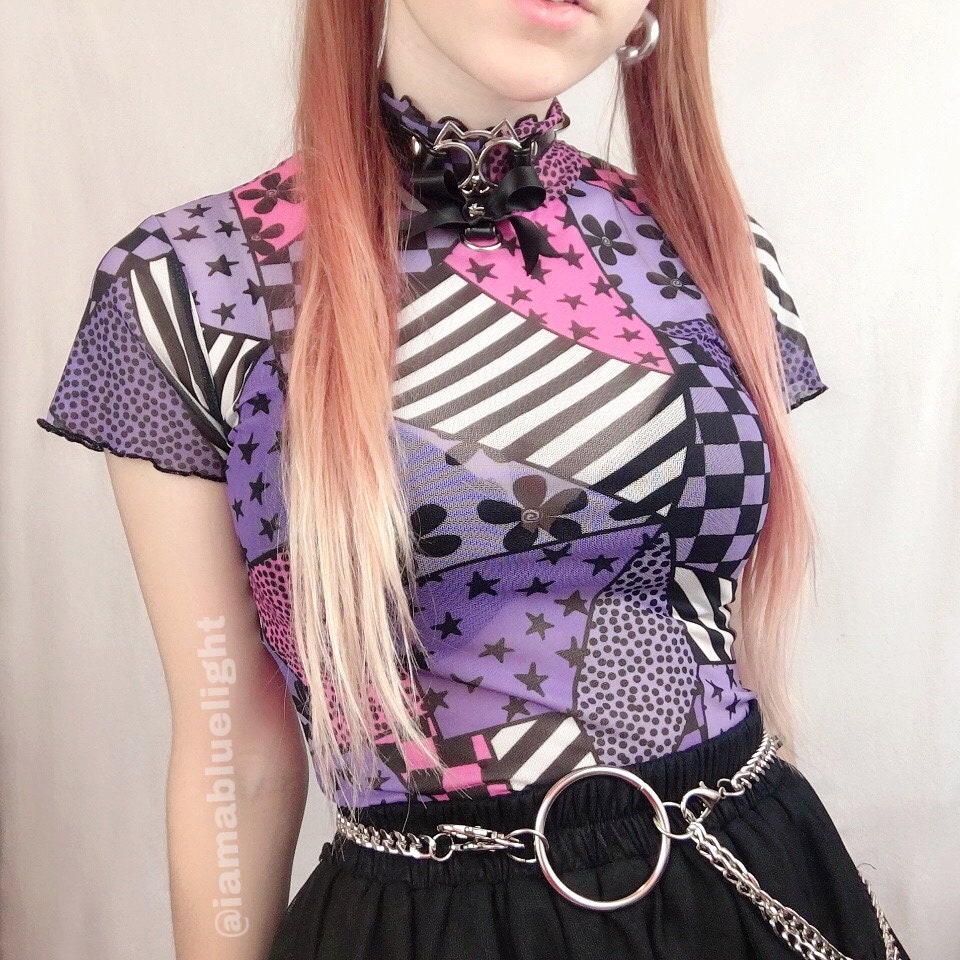 Modelled photo of the black ribbon cat choker, styled with a graphic purple and pink top, chain belt and black skirt for a nu goth fashion look