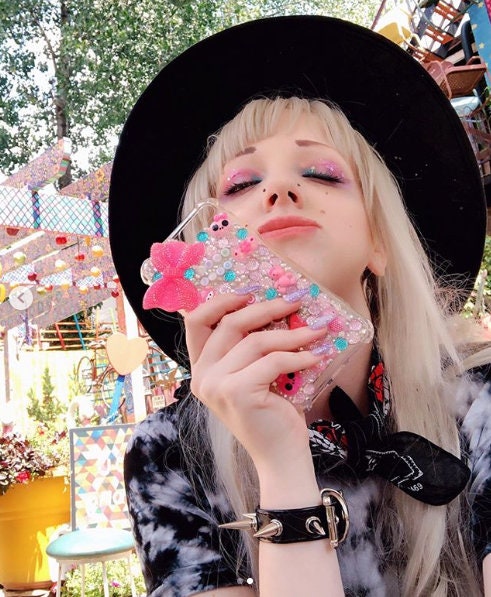 Lifestyle photo of black spike studded wristband, styled in pastel goth fashion with kawaii make-up and nails