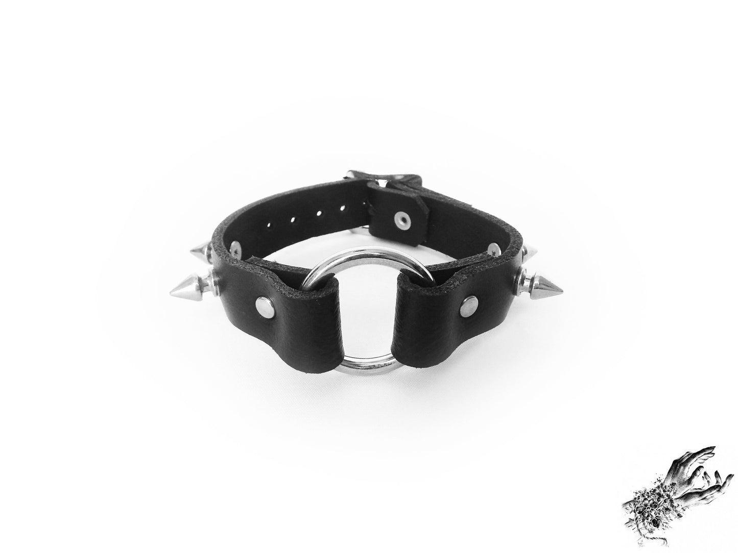 Black leather wristband featuring a central silver O ring, bold 13mm spike studs and an adjustable buckle at the back