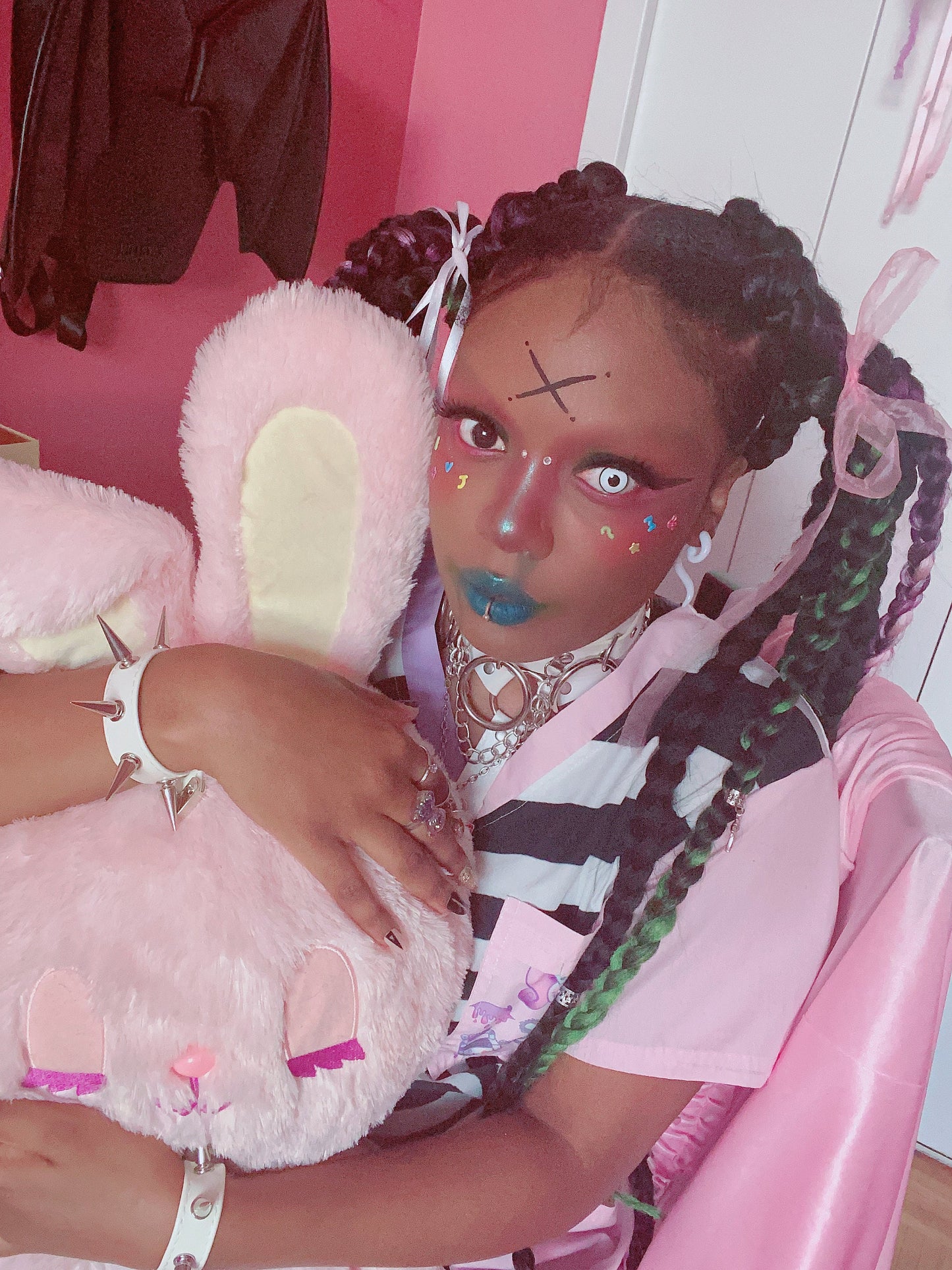 Modelled photo of white spike studded wristbands, styled with a white choker and pink t-shirt for a kawaii fashion aesthetic