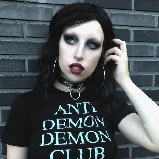 Black leather choker with a silver heart-shaped pendant styled with a black graphic t-shirt and gothic make-up