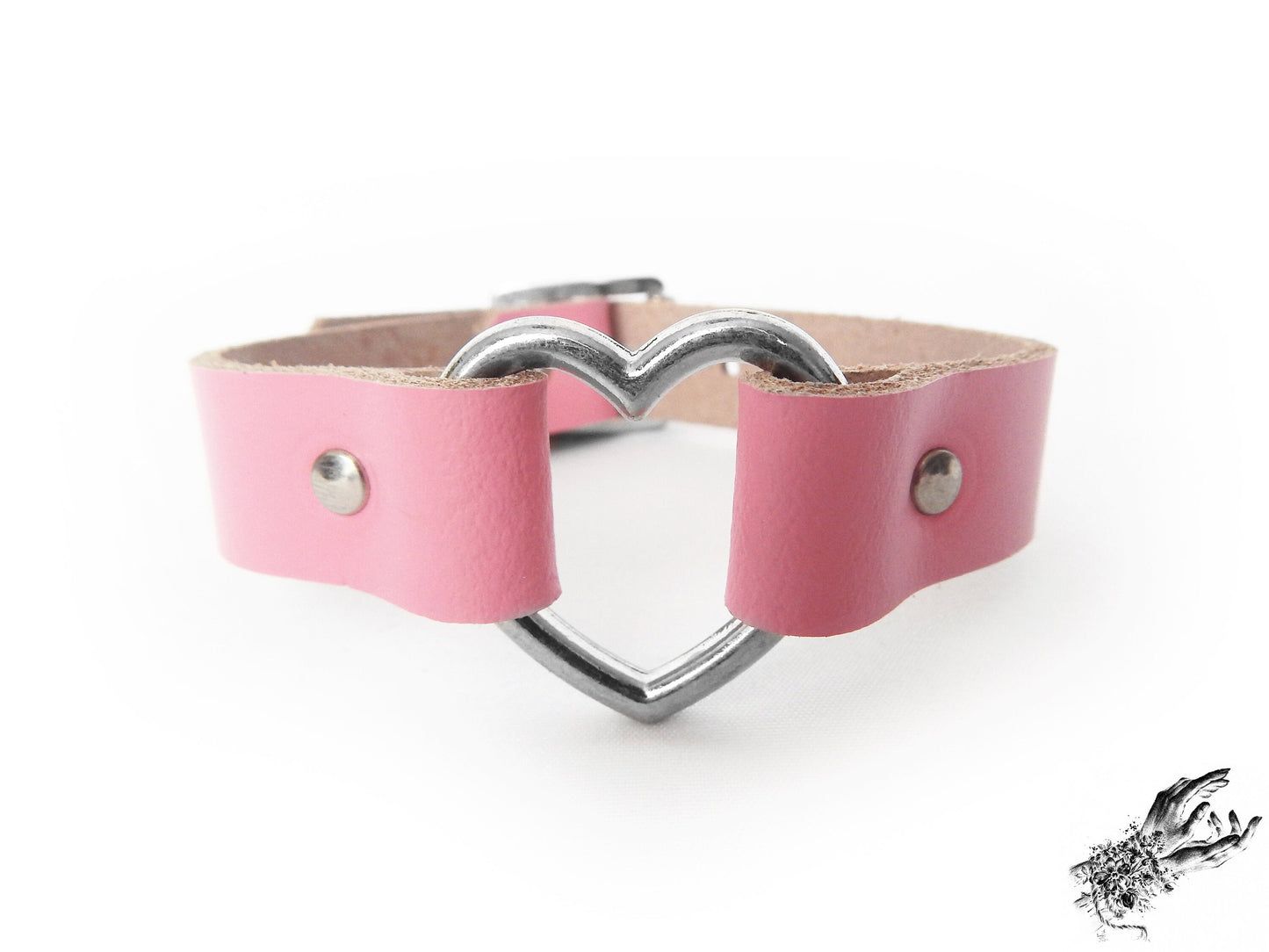Close-up of the pink leather heart ring wristband, showing the silver heart hardware and durable silver rivets