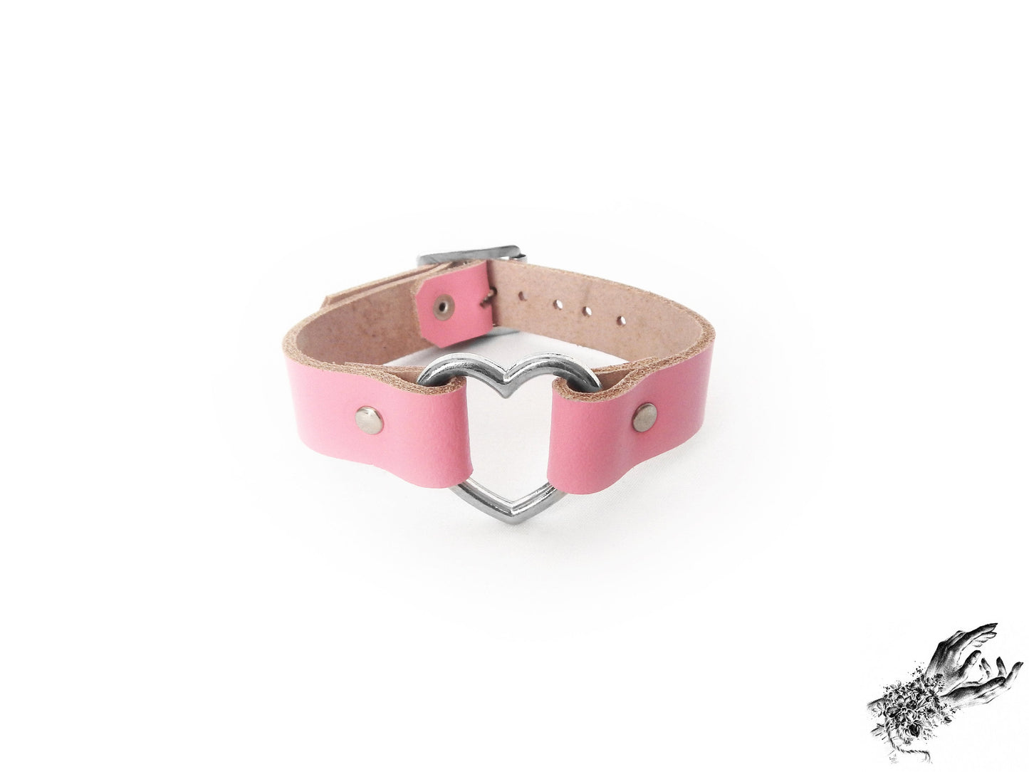 Pink leather wristband featuring a central silver heart ring and adjustable buckle at the back