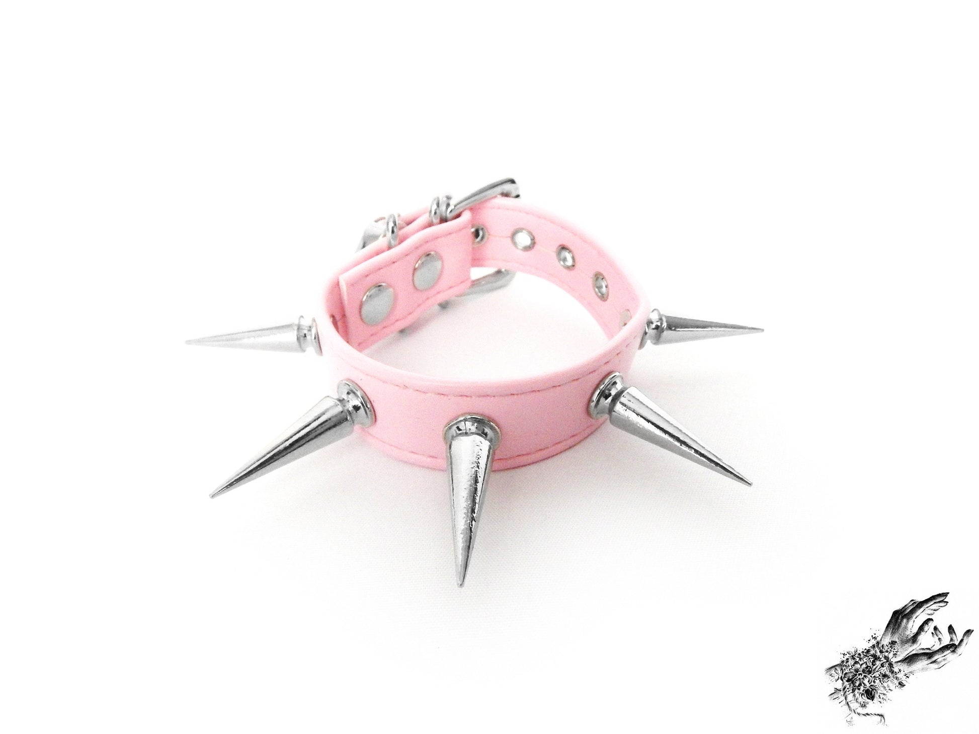 Close-up of the pink spike studded wristband showing the supple vegan leather strap and bold silver 25mm spike studs