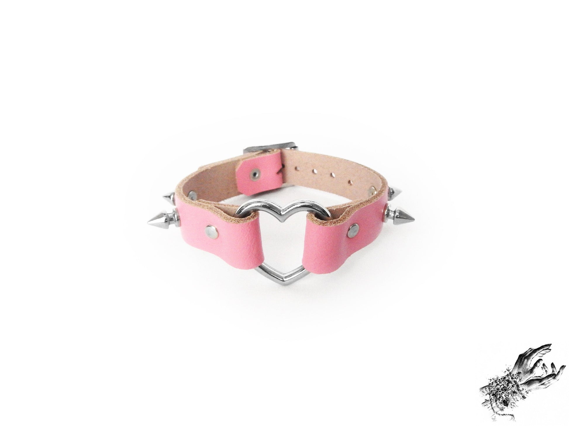 Pink leather wristband featuring a central silver heart ring and bold 13mm spike studs, made in the UK for pastel goth and kawaii fashion