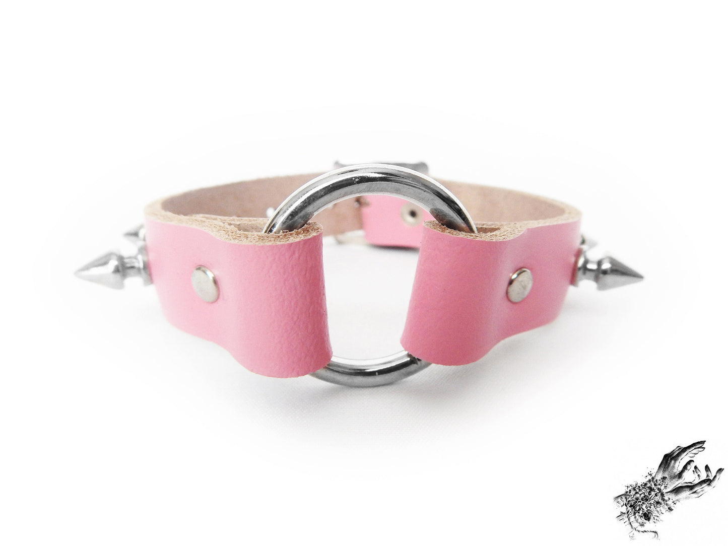 Close-up of the pink studded O ring wristband, showing the central silver O ring, bold 13mm spike studs and durable silver rivets on a white background